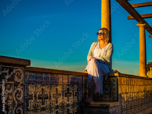 Woman sitting at Santa Luzia viewpoint in Lisbon 