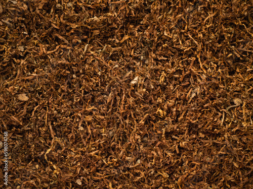 Background texture of tobacco finely chopped cooked processed product. Close-up of tobacco for rolling cigarettes. Place for text or background. Copy paste space for your brand or product and packagin