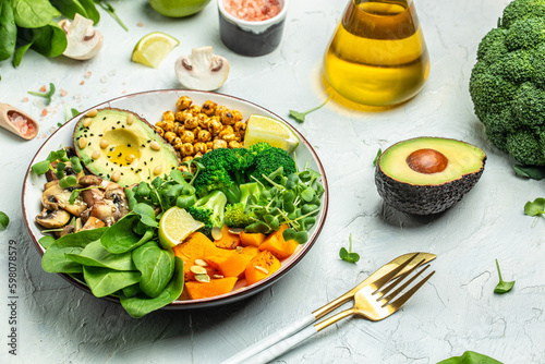 Fotografia vegetable vegetarian buddha bowl avocado, mushrooms, broccoli, spinach, chickpeas, pumpkin on a light background