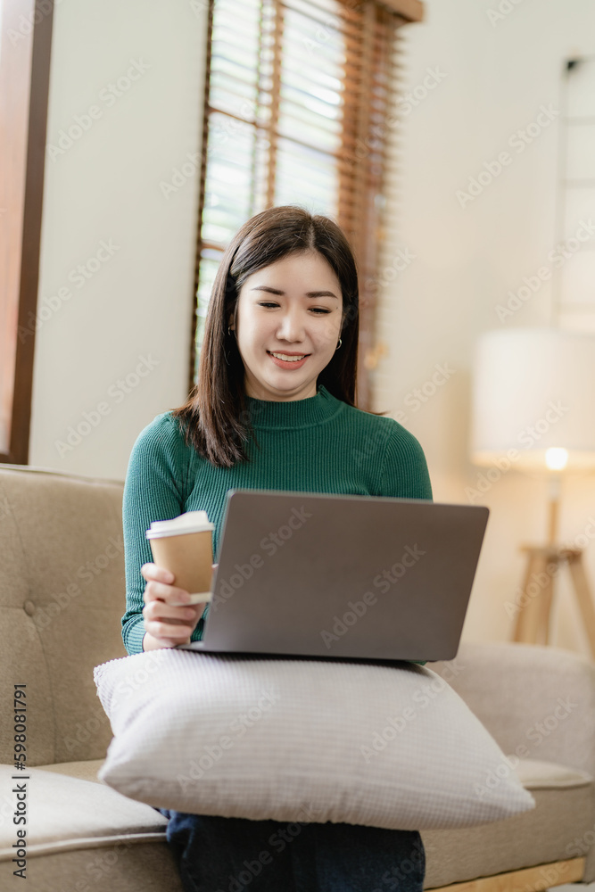 Pretty Asian woman using laptop to communicate about work happy work at home online communication lifestyle at home Pretty Asian woman using laptop to communicate about work happy work at home online communication lifestyle at home