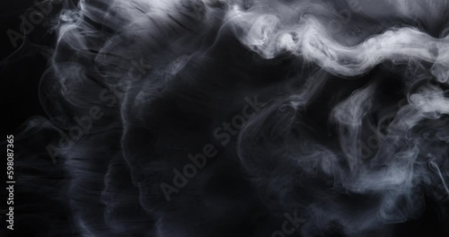 White smoke moves beautifully against a black background. Mockup for your logo. Wide angle horizontal wallpaper or web banner. Slow motion.