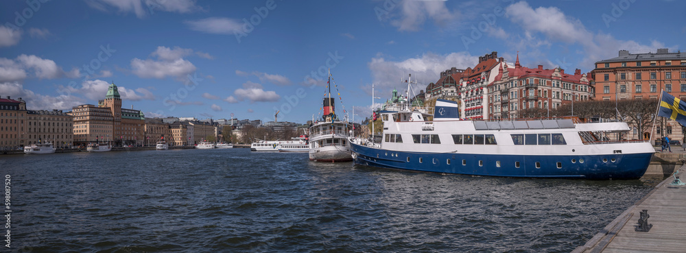 Tourist and archipelago commuting boats at the pier in the bay Nybroviken, a sunny spring day in Stockholm