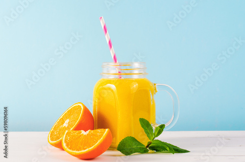 Orange Smoothie in a Jar, Vitamin Drink or Cocktail on Bright Background