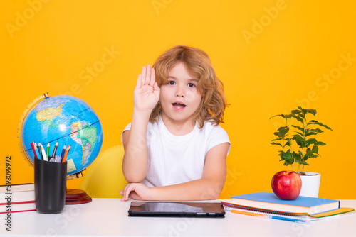 School child raising hands, willing to answer question. School and kids. Cute blonde child with a book learning. Knowledge day.