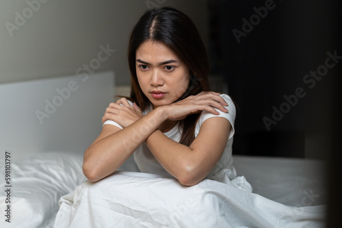 Stressed can not sleep asian young woman, girl sitting on bed in bedroom at home, suffering from insomnia, awake at night in bedroom, tired. Frustrated with problem, exhausted on nightmares.