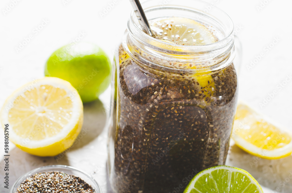 Chia Infused Water with Lemon and Lime in Jars, Healthy Citrus Drink on Bright Background Chia Infused Water with Lemon and Lime in Jars, Healthy Citrus Drink on Bright Background
