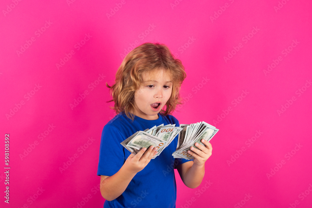 Money bills, salary payment. Kid having a lot of hundred dollars isolated on studio background. Money bills, salary payment. Kid having a lot of hundred dollars isolated on studio background.