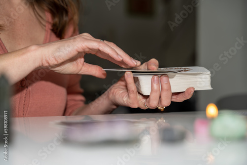 mains d'une tarologue avec un tas de cartes divinatoires photo