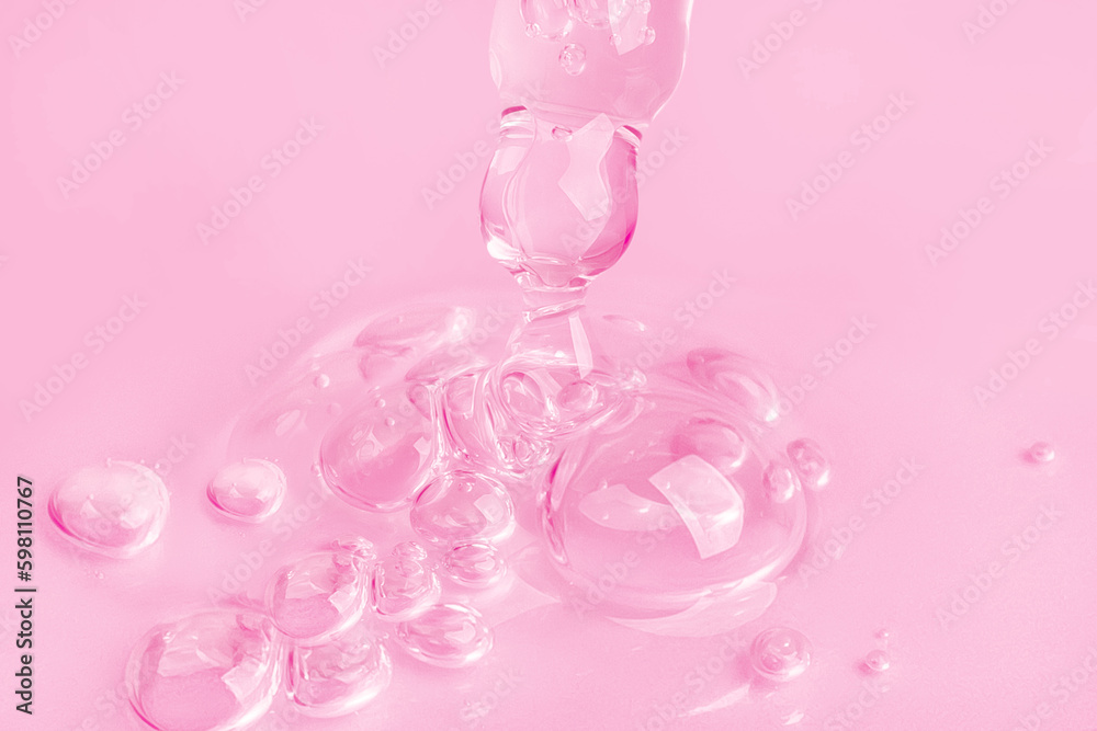 Dropping gel from an eyedropper on a pink background. Cosmetics Lab. Serum, gel, retinol, oil.