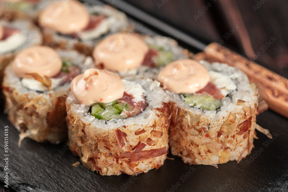 Close up Salmon sushi roll with tuna flakes and souse close-up - sushi asian menu and Japanese food Close up Salmon sushi roll with tuna flakes and souse close-up - sushi asian menu and Japanese food