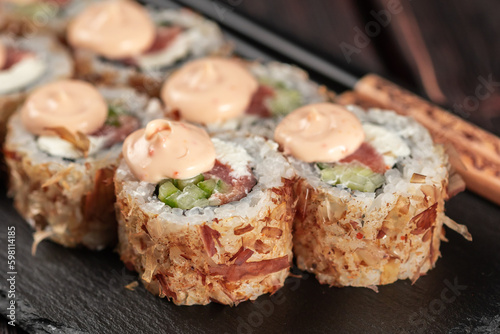 Close up Salmon sushi roll with tuna flakes and souse close-up - sushi asian menu and Japanese food