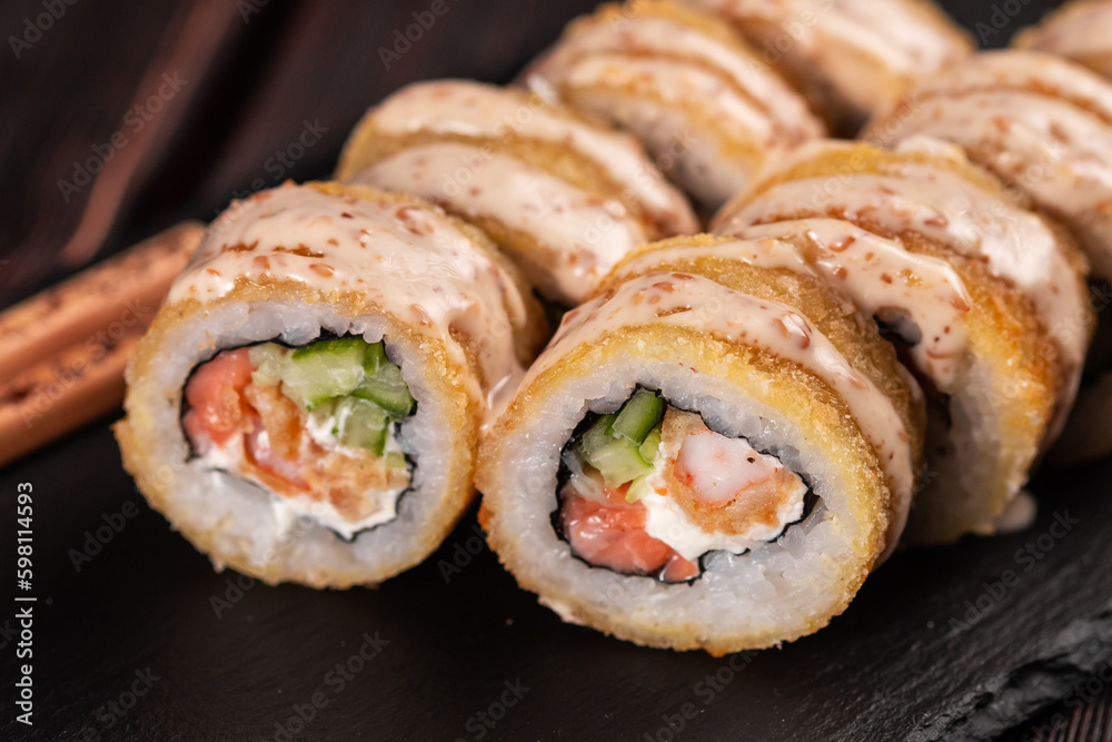Roll with fish sushi with chopsticks close up - asian food concept