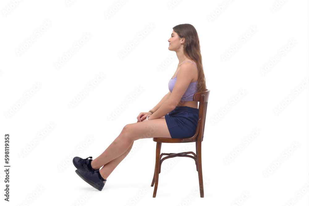 side view of a young girl sitting on chair stretched legs on white background side view of a young girl sitting on chair stretched legs on white background