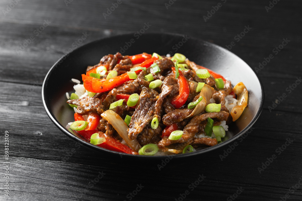 Stir fry Crispy Orange Beef with sweet peppers, onion and rice. Asian food