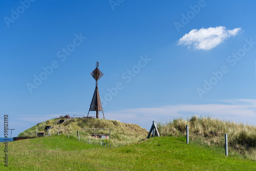 Aussichtsplattform Westkopf im Westen von Baltrum mit grüner Wiese und Zaun bei sonnigem Wetter photo
