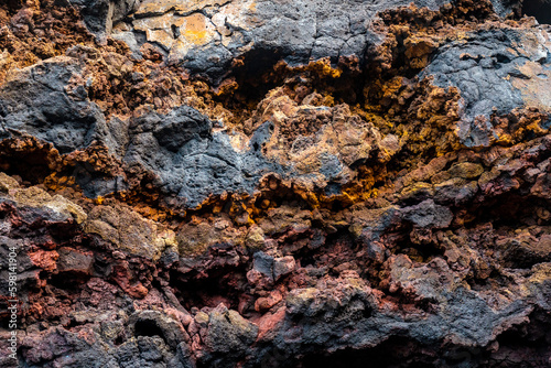 Detail of the red and yellow colors in the volcanic stones in Charco Manso on the island of El Hierro. Canary Islands