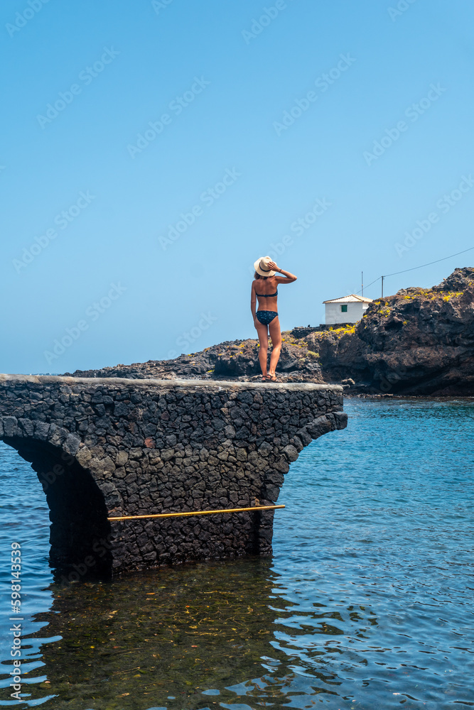 A young woman on vacation in the seaside tourist village Tamaduste on the island of El Hierro, Canary Islands, Spain