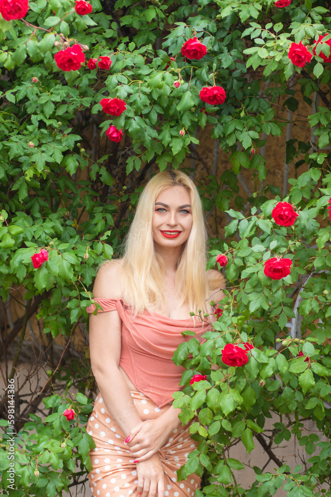 Beautiful woman with long blonde hair and red lips wearing pink clothes