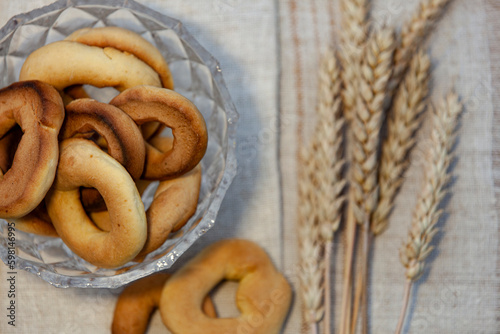 Obraz na płótnie Homemade baking. Dry bagels in a glass vase on a napkin against the background of spikelets of wheat w salonie