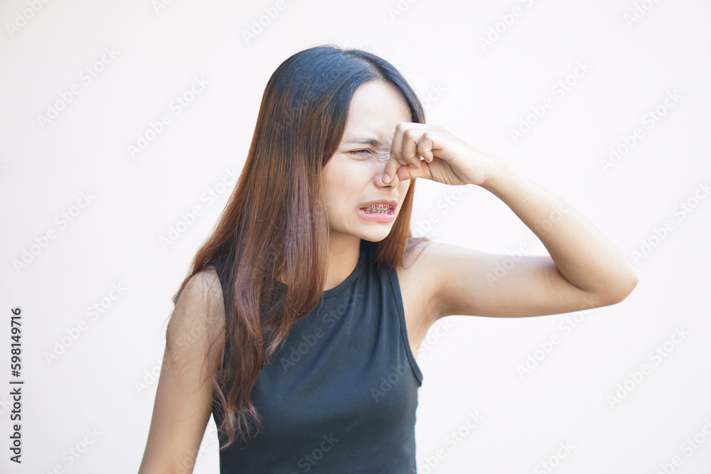 Asian woman covering her nose with her hands due to a bad smell Asian woman covering her nose with her hands due to a bad smell