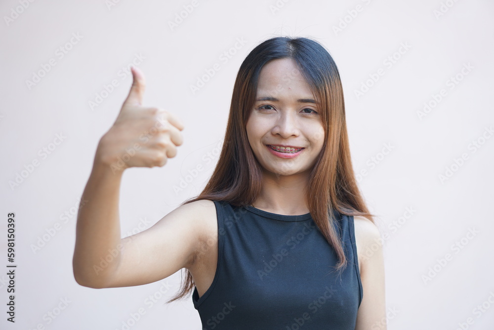 woman holds up her thumb as a sign of excellence.