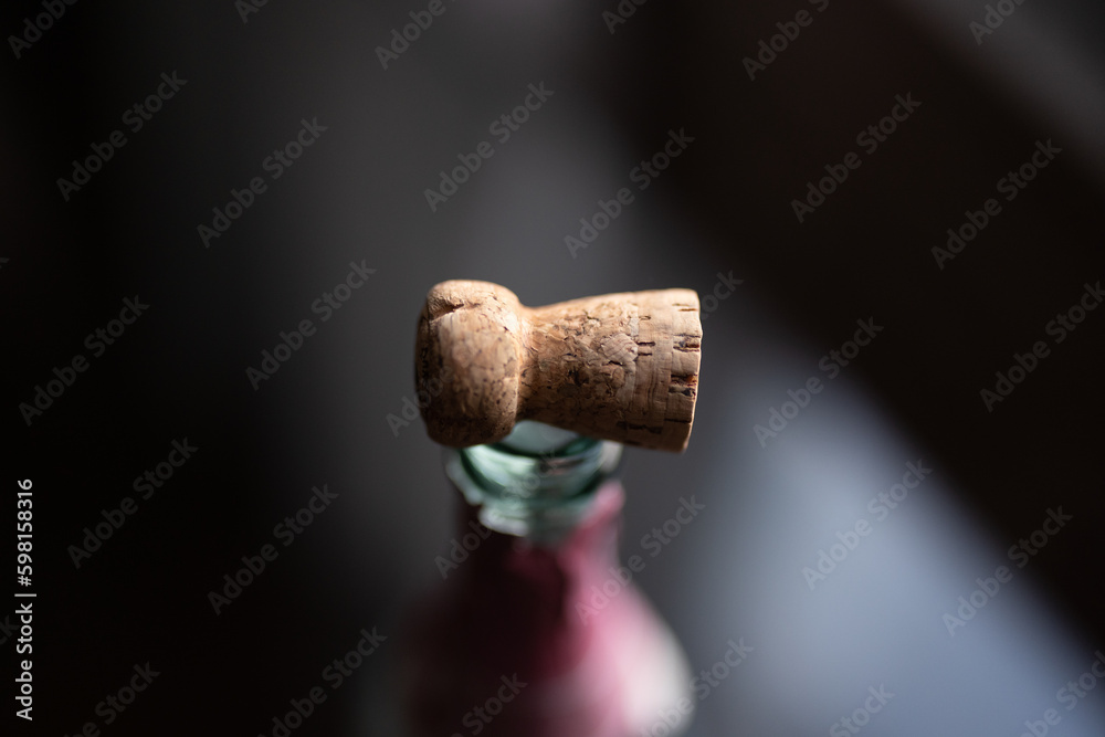 Cork on a bottle of champagne on a glass table by a window at sunset