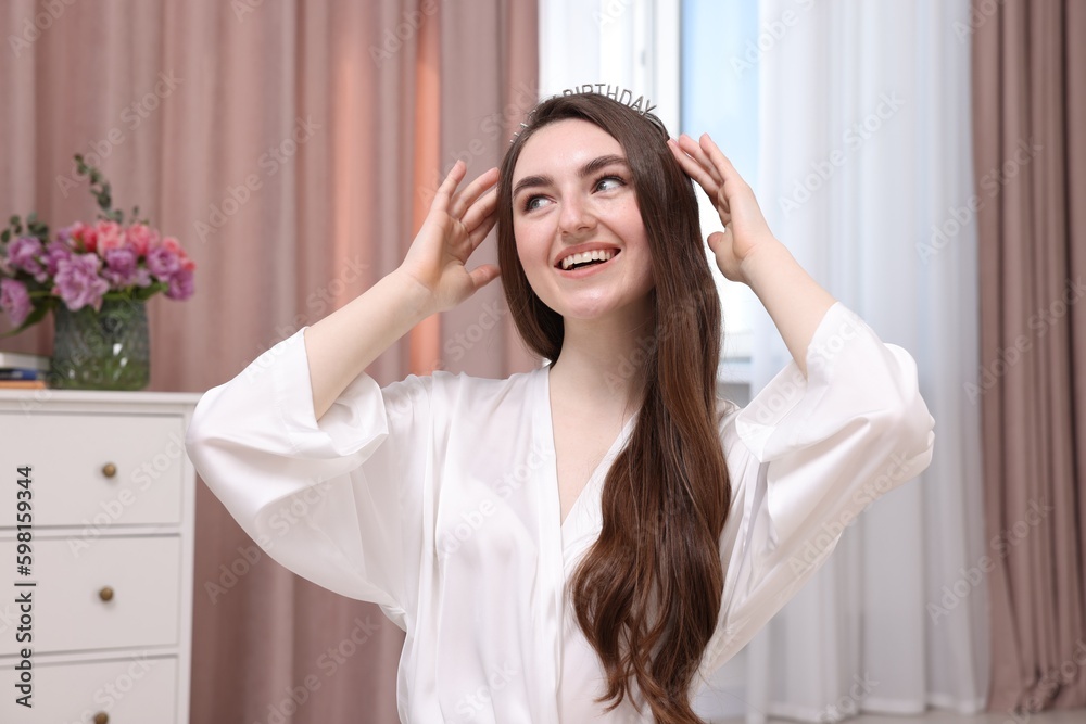 Naklejka premium Beautiful young woman in headband in room. Happy Birthday