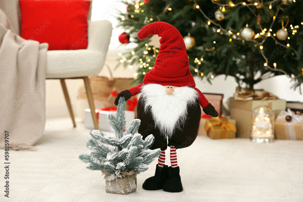 Obraz premium Funny Christmas gnome and tree on floor in room with festive decoration