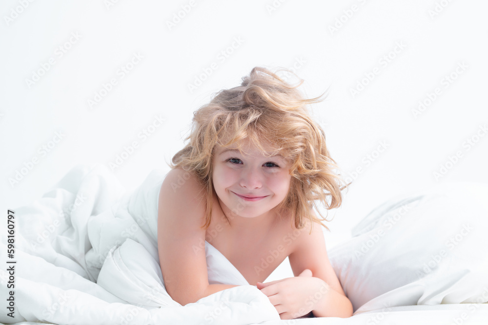 Funny smiling child enjoys sunny morning. Good time at home. Kid wakes up from sleep. Child wakes up in morning in bed. Morning awakening little child in bed. Funny smiling child enjoys sunny morning. Good time at home. Kid wakes up from sleep. Child wakes up in morning in bed. Morning awakening little child in bed.