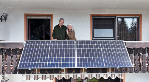 Eine Frau und ihr Mann freuen sich über die neue Solaranlage auf dem Balkon photo