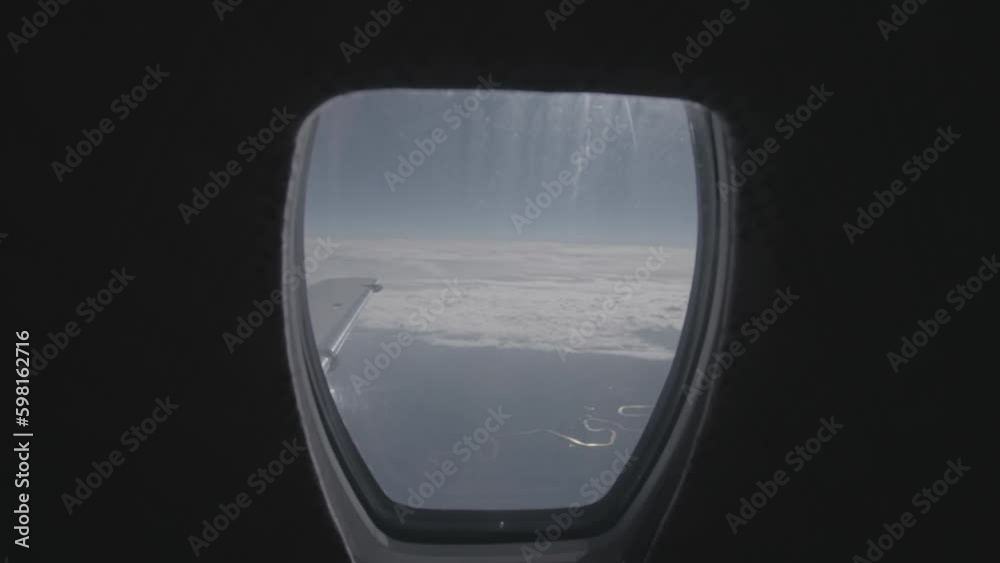 Slowmotion shot filming the wing of a private airplane jet in the sky with a blue sky and clouds in the background LOG Slowmotion shot filming the wing of a private airplane jet in the sky with a blue sky and clouds in the background LOG