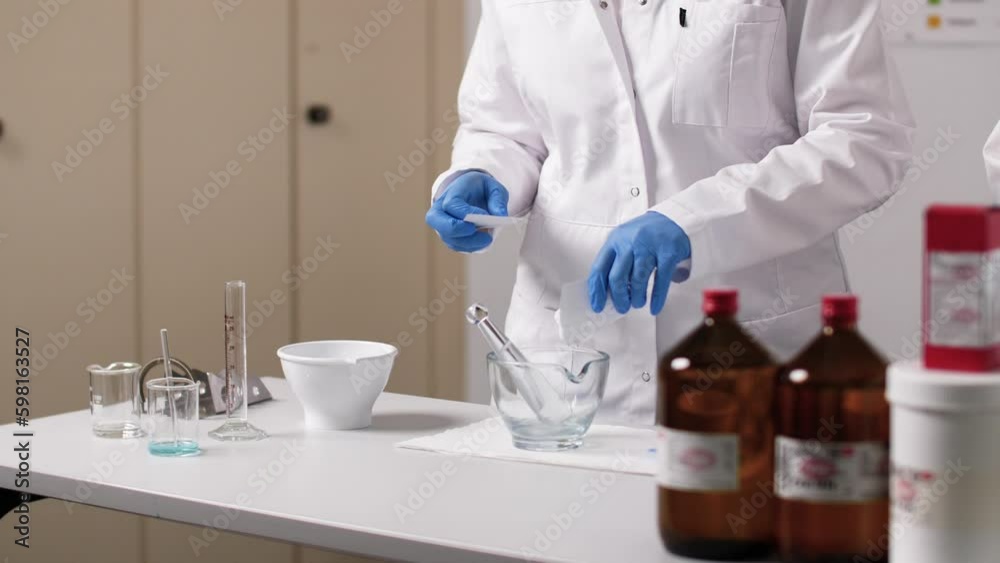 A cream is mixed in a glass bowl. The PTA wears gloves and a white coat A cream is mixed in a glass bowl. The PTA wears gloves and a white coat