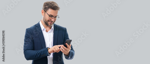 Man in suit using smart phone. Portrait attractive cheerful guy using phone, calling on mobile phone. Handsome man with smart phoneon studio isolated background. Banner, copy space.