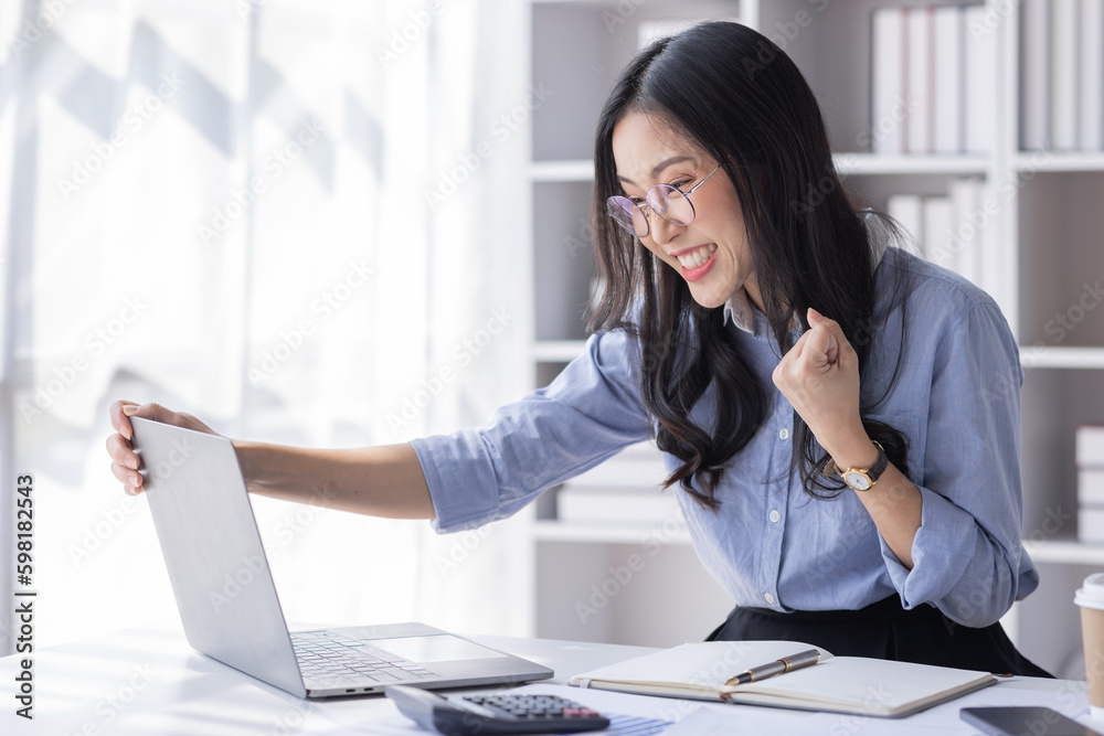 Portrait of Happy Excited young asian woman at workplace office desk, successful Asian female reading good news technology online, employee freelance finance concepts. Portrait of Happy Excited young asian woman at workplace office desk, successful Asian female reading good news technology online, employee freelance finance concepts.