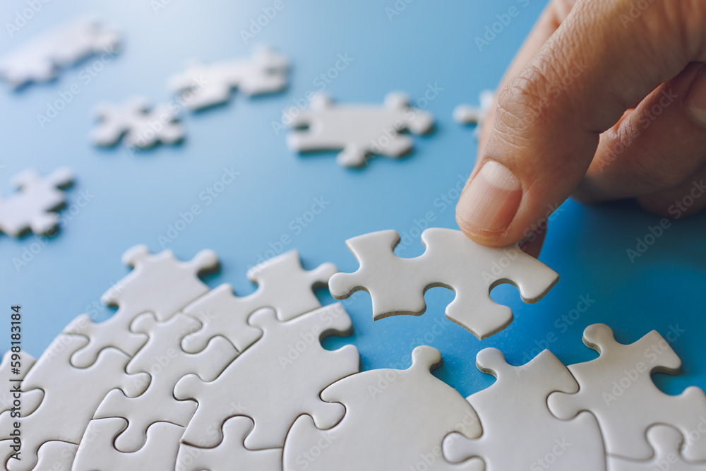 Hand put the last piece of jigsaw puzzle to complete the mission. Completing final task, missing jigsaw puzzle pieces and business concept with a puzzle piece missing. Hand put the last piece of jigsaw puzzle to complete the mission. Completing final task, missing jigsaw puzzle pieces and business concept with a puzzle piece missing.