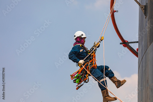 Focus male swing rope worker down height tank roof rope access safety inspection of thickness storage tank