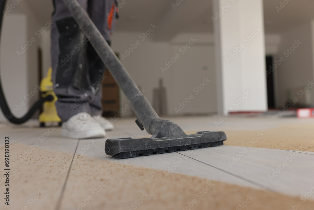 Foreman does industrial cleaning of laminate floor in room