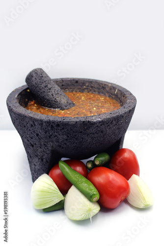 Comida mexicana. salsa roja en molcajete, molcajete mexicano prehispanico, jitomate, cebolla, chile verde