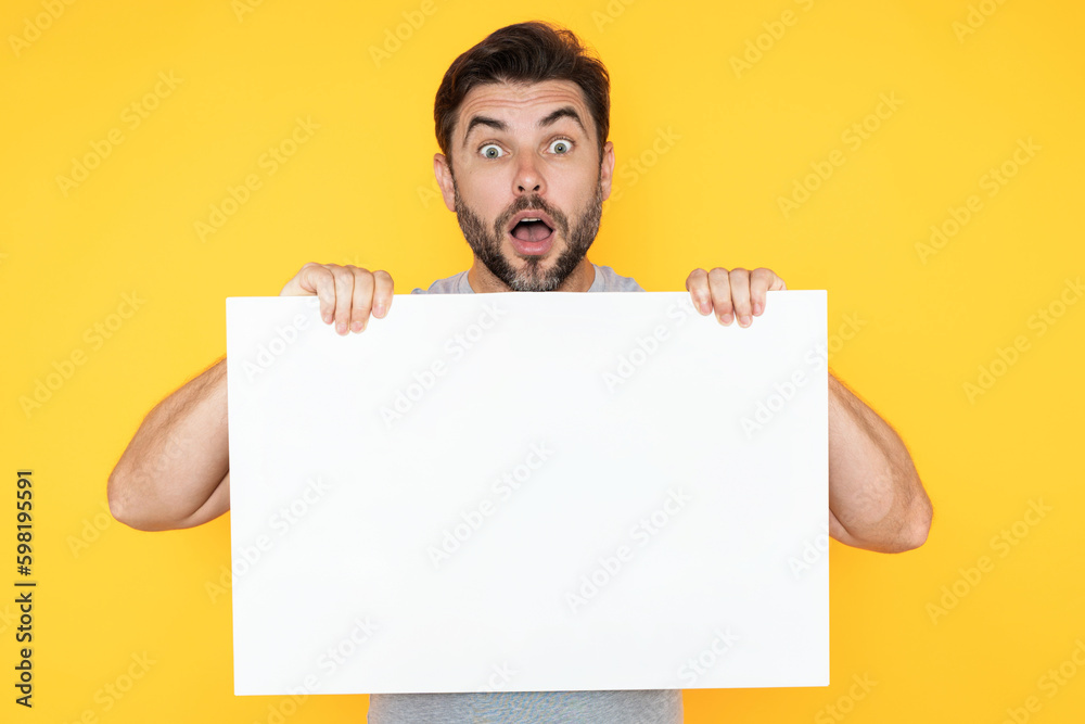 Amazed man showing promo blank board on studio background. Blank signboard with copyspace. Advertisement concept. Ad board with copy space, blank mockup. Blank signboard, placard. Amazed man showing promo blank board on studio background. Blank signboard with copyspace. Advertisement concept. Ad board with copy space, blank mockup. Blank signboard, placard.