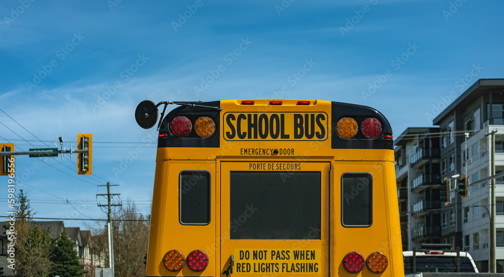 School Bus on urban street road in the morning. School bus driving along suburban street in Vancouver Canada