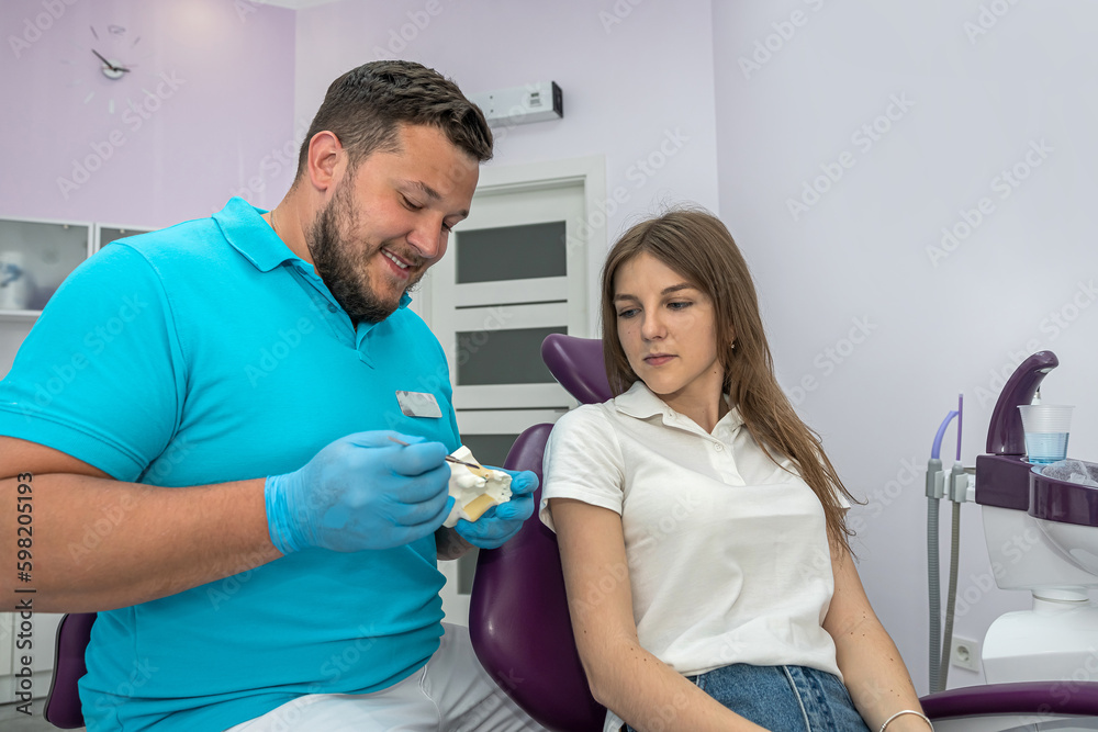 Dentist with hand pointing image and talking to female patient about medication Dentist with hand pointing image and talking to female patient about medication