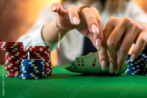woman's hand on a pile of poker chips at a round poker table. © RomanR