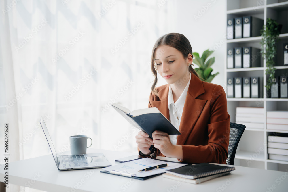 woman reading book while sitting at in home office woman reading book while sitting at in home office
