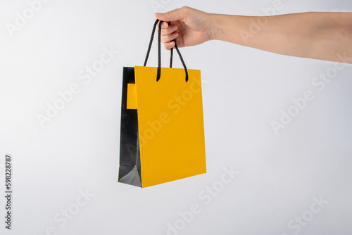 Yellow paper bags in hand for shopping isolated on white background