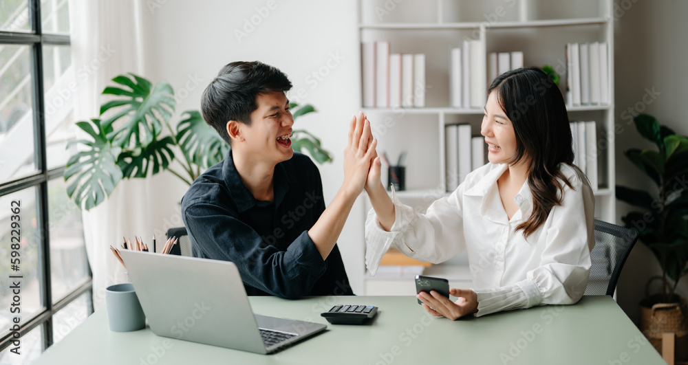 Young Asian business team creative businesspeople coworker, teamwork celebrating achievement and in planning design in creative in office. Young Asian business team creative businesspeople coworker, teamwork celebrating achievement and in planning design in creative in office.