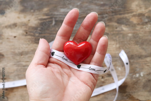 Small red heart in woman's hand