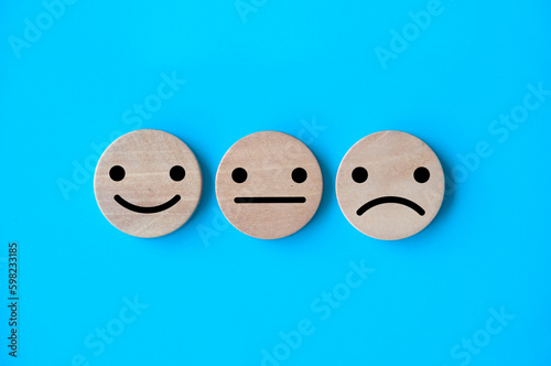 Neutral, happy and sad emotion faces on wooden cubes. Customer satisfaction and evaluation concep