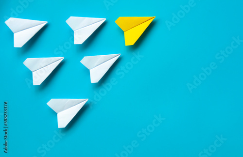 Free Download Top view of paper airplane - Yellow paper airplane origami leading other white airplane on blue background. Leadership concept. - GFXLoad