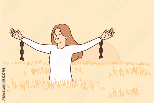 Woman feels freedom standing in field among tall grass and waving arms with fragments of chains Generative AI