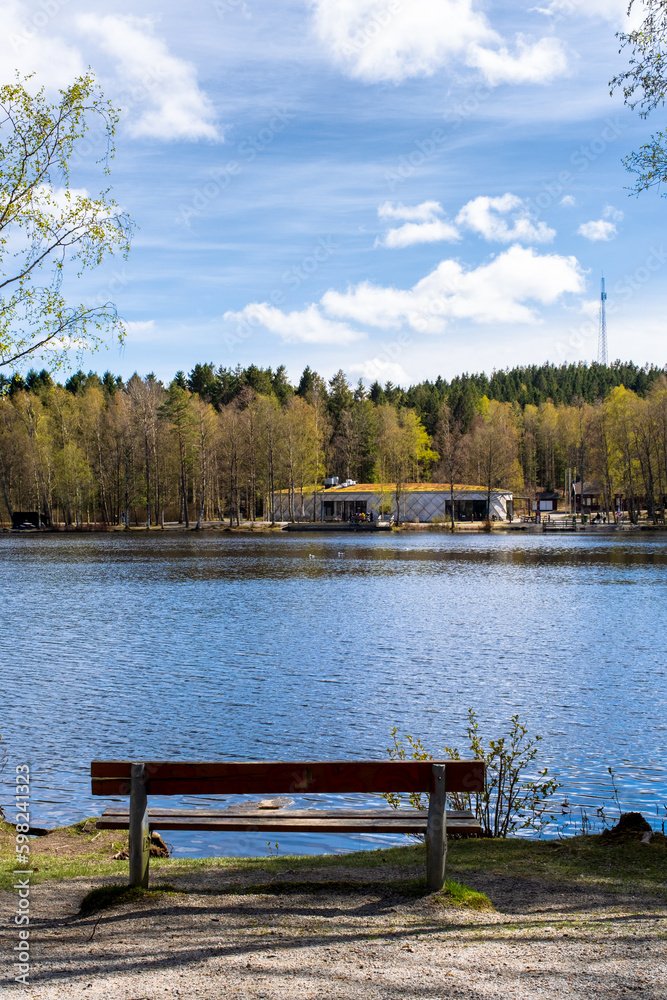Local cafe next to a lake meant for social gathering during sunny spring day in Gothenburg Sweden with a bench to relax
